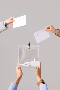 Eller oy pusulasına beyaz arka planda oy veriyor. Seçim kavramı