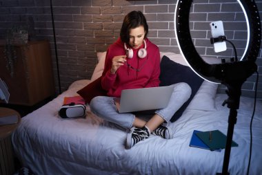 Gece yatak odasında dizüstü bilgisayarla çalışan bir kız öğrenci.