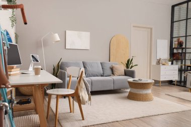 Oturma odası, kanepe ve öğrenci masası.