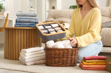 Farklı temiz elbiseli bir kadın evde yerde oturuyor.