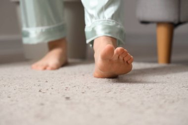 Halıda yürüyen çıplak ayaklı bir kadın. Yakın çekim.