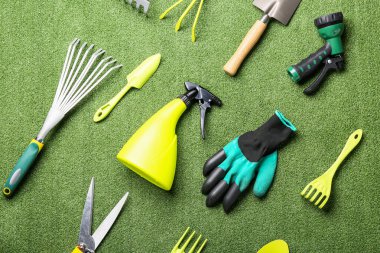 Yeşil çim arka planda bahçe aletleri. Üst görünüm