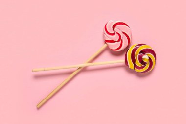 Pembe bir arka plan üzerinde tatlı lolipop