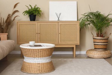 Halı, çekmece, sehpa ve çiçekli bir oturma odası.