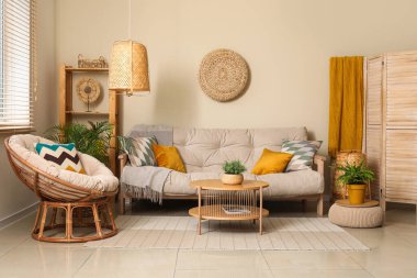 Rahat kanepesi, sehpası, koltuğu ve çiçekleri olan güzel bir oturma odası.