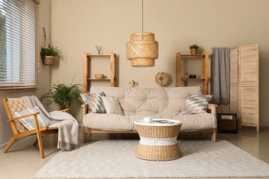 Rahat kanepesi, sehpası, koltuğu ve lambası olan bir oturma odası.