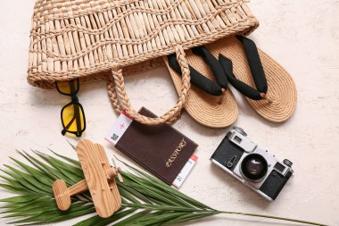 Şık plaj aksesuarları, pasaport, fotoğraf makinesi ve arka planda ahşap uçak kompozisyonu