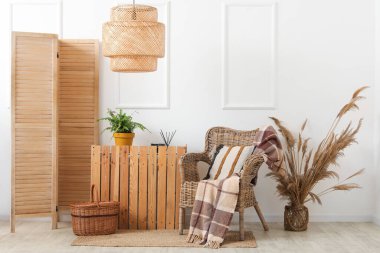 Oturma odasının iç tarafında ekose ve yastıklı bir koltuk.