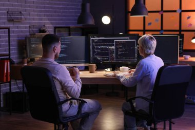 Geceleri ofiste çalışan genç programcılar, arka plan