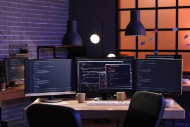 Geceleri bilgisayar monitörlü programcının işyeri
