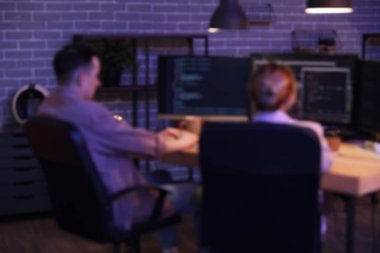 Geceleri ofiste çalışan programcıların bulanık görüntüsü