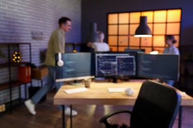 Geceleri ofiste çalışan programcıların bulanık görüntüsü