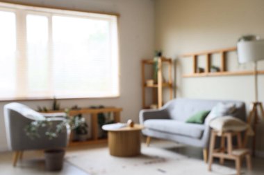 Gri kanepesi, raf ünitesi, sehpası ve lambası olan güzel bir oturma odası.