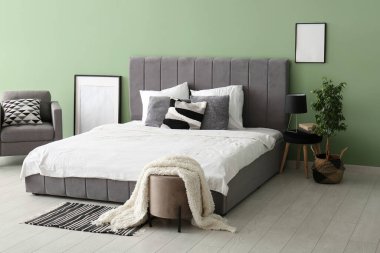 Rahat yatak, resim çerçevesi ve şık bir yatak odasında koltuk.