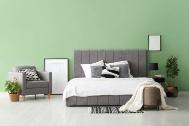 Rahat yatak, resim çerçevesi ve şık bir yatak odasında koltuk.