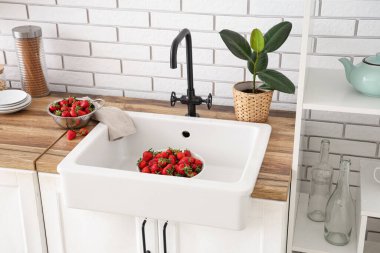 Mutfak lavabosunda lezzetli çilek kasesi.