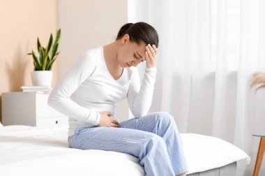 Evde yatağında sistit hastası olan genç bir kadın.