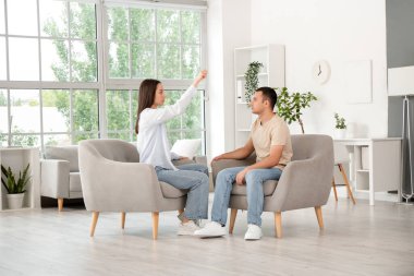 Genç adam psikologun ofisinde hipnoz seansı sırasında koltukta oturuyor.