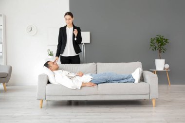 Cep saati olan kadın psikolog ofisteki genç adamı hipnotize ediyor.