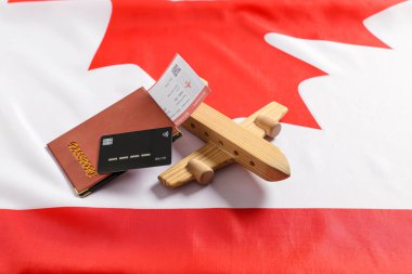 Tahta uçak, pasaport, bilet ve Kanada bayrağında kredi kartı