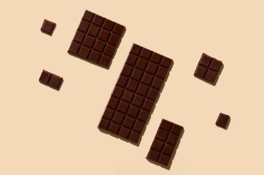 Renk arkaplanında lezzetli siyah çikolata çubukları olan kompozisyon