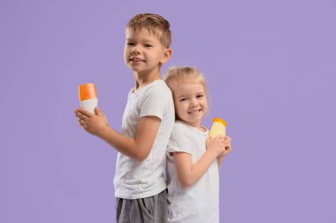 Leylak arka planında güneş kremi olan şirin çocuklar.