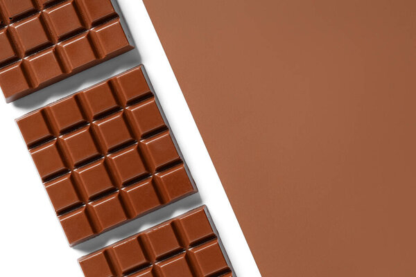 Composition with tasty chocolate bars on color background
