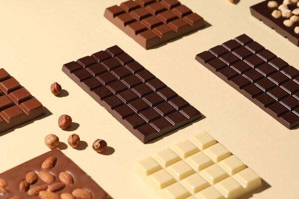 Composition with tasty chocolate bars and nuts on color background