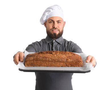 Male baker holding tray with rye bread on white background