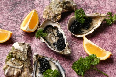 Limonlu lezzetli istiridye ve mor arka planda siyah havyar.