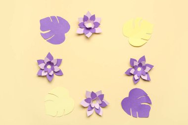 Renkli origami çiçeklerinden yapılmış çerçeve ve bej arkaplanda yapraklar