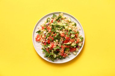 Sarı arka planda lezzetli tabakta salata.