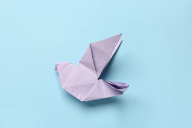 Mavi arkaplanda mor origami kuşu