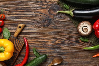 Kahverengi ahşap mutfak masasında taze sebze kesme tahtası.