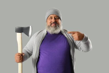 Gri arka planda baltayı işaret eden olgun oduncunun portresi