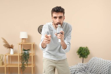 Evde mikrofonlu yakışıklı bir adam şarkı söylüyor.