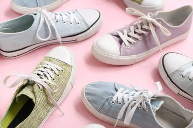 Pembe arka planda farklı şık spor ayakkabılar.