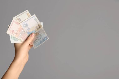 Gri arka planda Bulgar lev banknotlarını tutan kadın