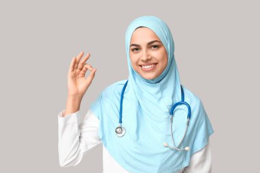 Kadın Müslüman doktorun portresi gri arka planda iyi görünüyor