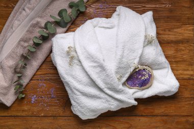 Deniz tuzu, okaliptüs ve ahşap arka planda çigila çiçekli beyaz bornoz.