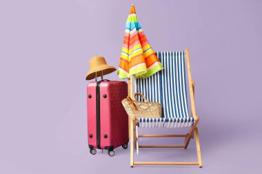 Renkli şemsiyeli çizgili güverte sandalyesi ve leylak arka planda valizi.