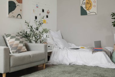 Öğrenci odasının içinde yatak ve kanepe.