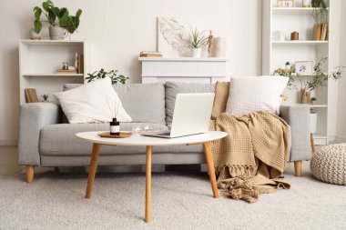 Reed dağıtıcı ve dizüstü bilgisayar evdeki sehpanın üzerinde.