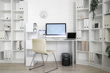 Modern işyeri ve raf üniteleri olan hafif bir ofis.
