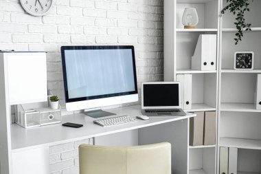 Modern işyeri ve raf ünitesi olan hafif bir ofis.