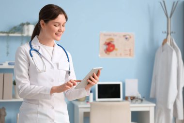 Klinikte tablet bilgisayar kullanan kadın göz doktoru.