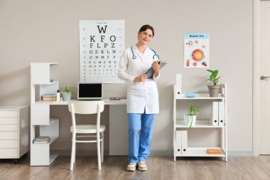 Klinikte defteri olan kadın göz doktoru.