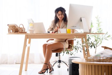 Genç Afro-Amerikalı grafik tasarımcısı masada tabletle çalışıyor.