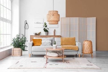 Gri kanepeli ve ahşap masalı aydınlık oturma odasının içi.