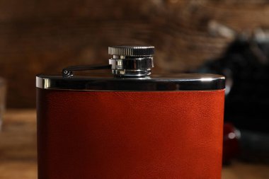 Ahşap arka planda yeni bir cep şişesi, yakın plan.